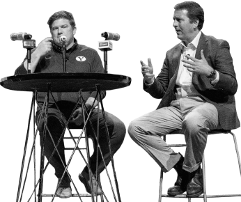 two men at a table hosting a podcast with microphones