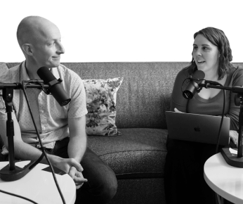 two people talking on a couch with microphones