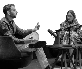two people sitting and talking with a microphone
